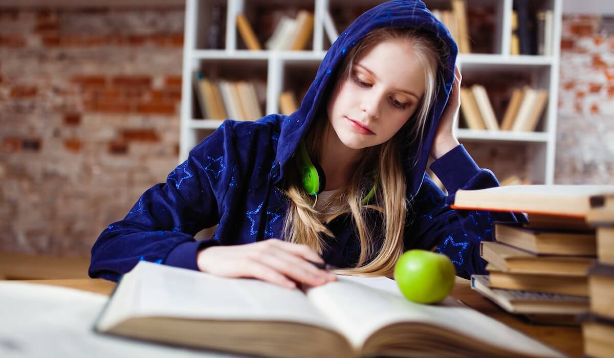 Українська школярка читає німецьку книгу в школі