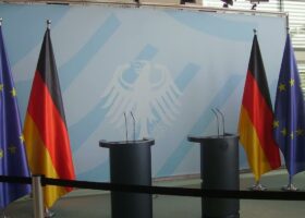 На сцене стоят флаги Германии и Евросоюза-RU