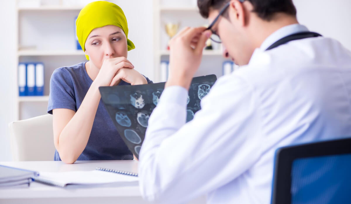 Frau, die sich einer Krebsbehandlung unterzieht, spricht mit ihrem Arzt-DE