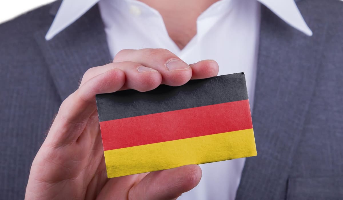 Mann hält deutsche Flagge und lädt zu Bamf-Kursen ein-DE
