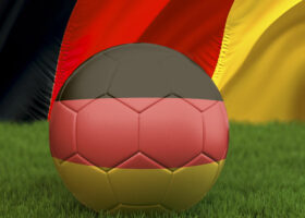 Лежащий на газоне мяч в цветах немецкого флага. Ru