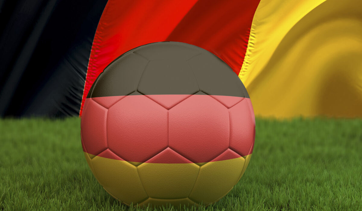 Ein Ball in den Farben der deutschen Flagge liegt auf dem Rasen. De