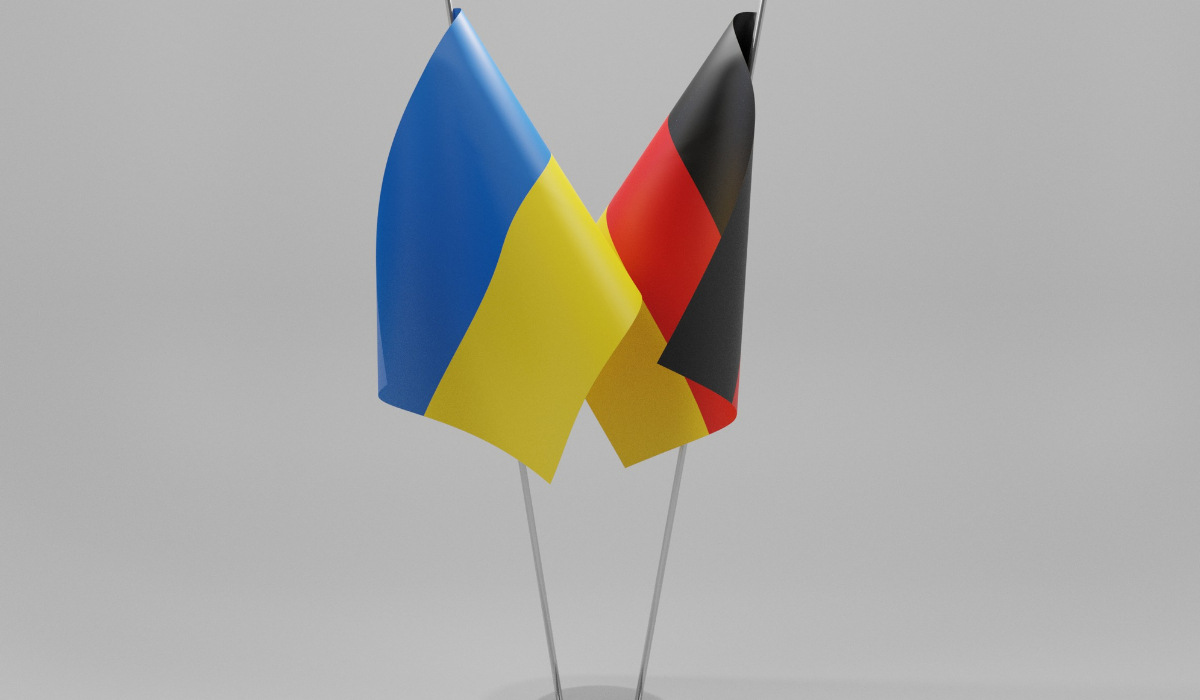 Die Flagge der Ukraine und die Flagge von Deutschland auf grauem Hintergrund. De