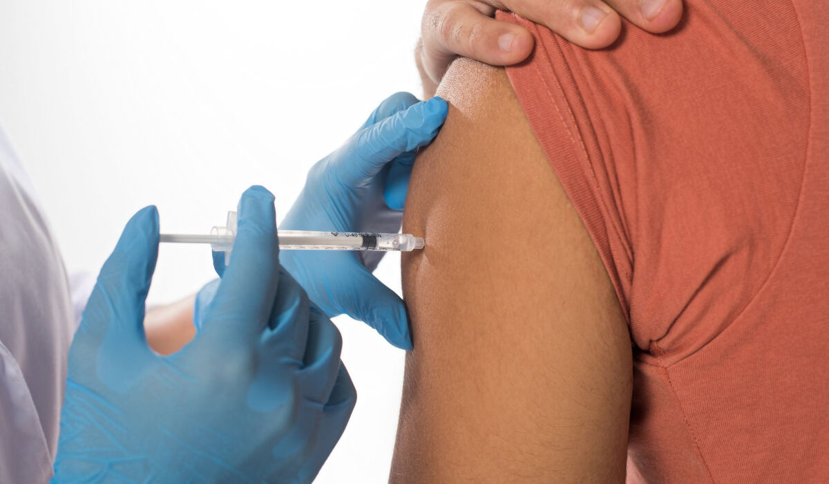 Врач делает женщине прививку от гриппа в Германии-RU