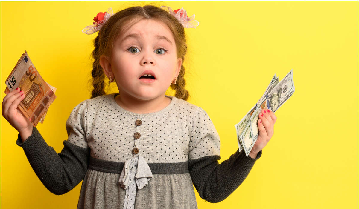 Das Mädchen hält das Geld Kindergrundsicherung in der Hand-DE