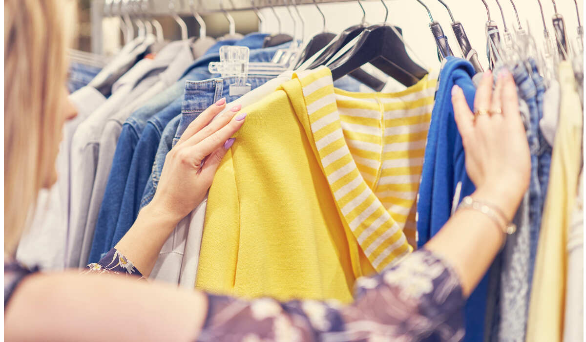 Женщина выбирает одежду в магазине-RU