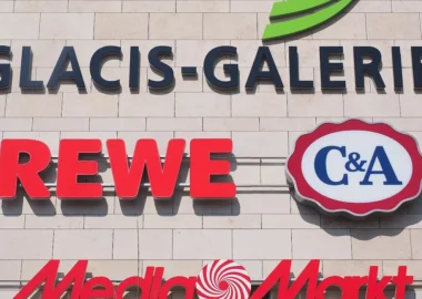 Большие вывески известных немецких магазинов на белой стене