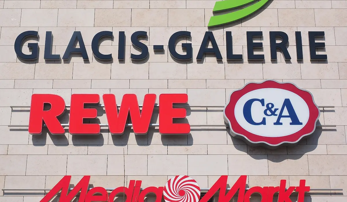 Великі вивіски відомих німецьких магазинів на білій стіні