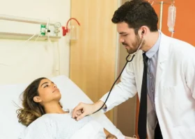 Bei der ärztlichen Untersuchung hört der Arzt mit einem Stethoskop das Herz des Patienten ab.