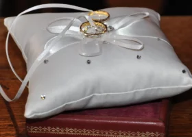 Die Eheringe liegen auf einem kleinen weißen Kissen